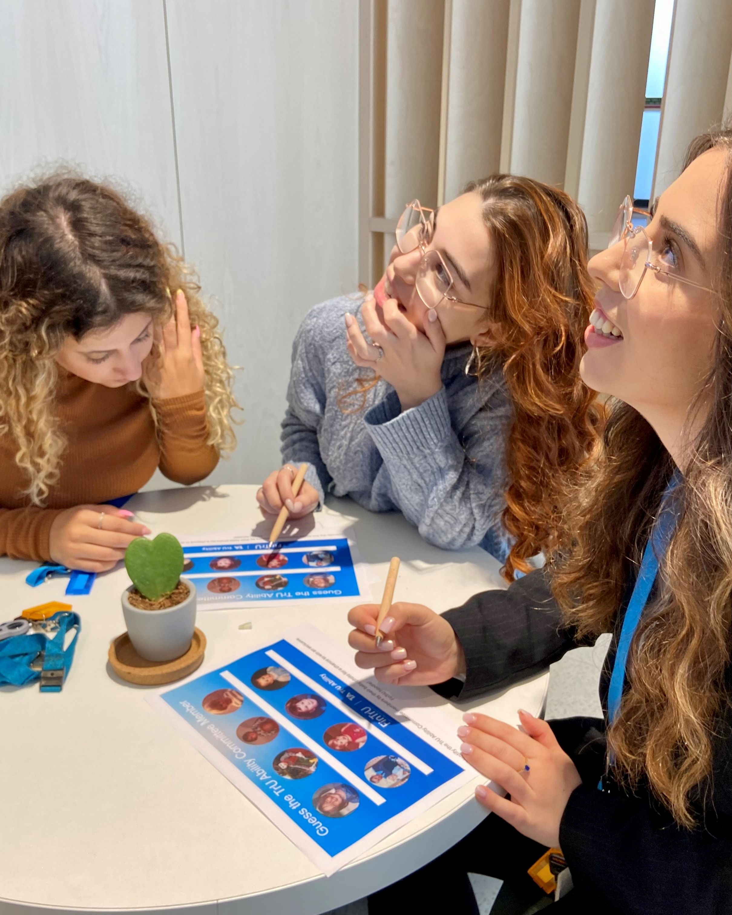 Three women sitting at a table doing a quiz