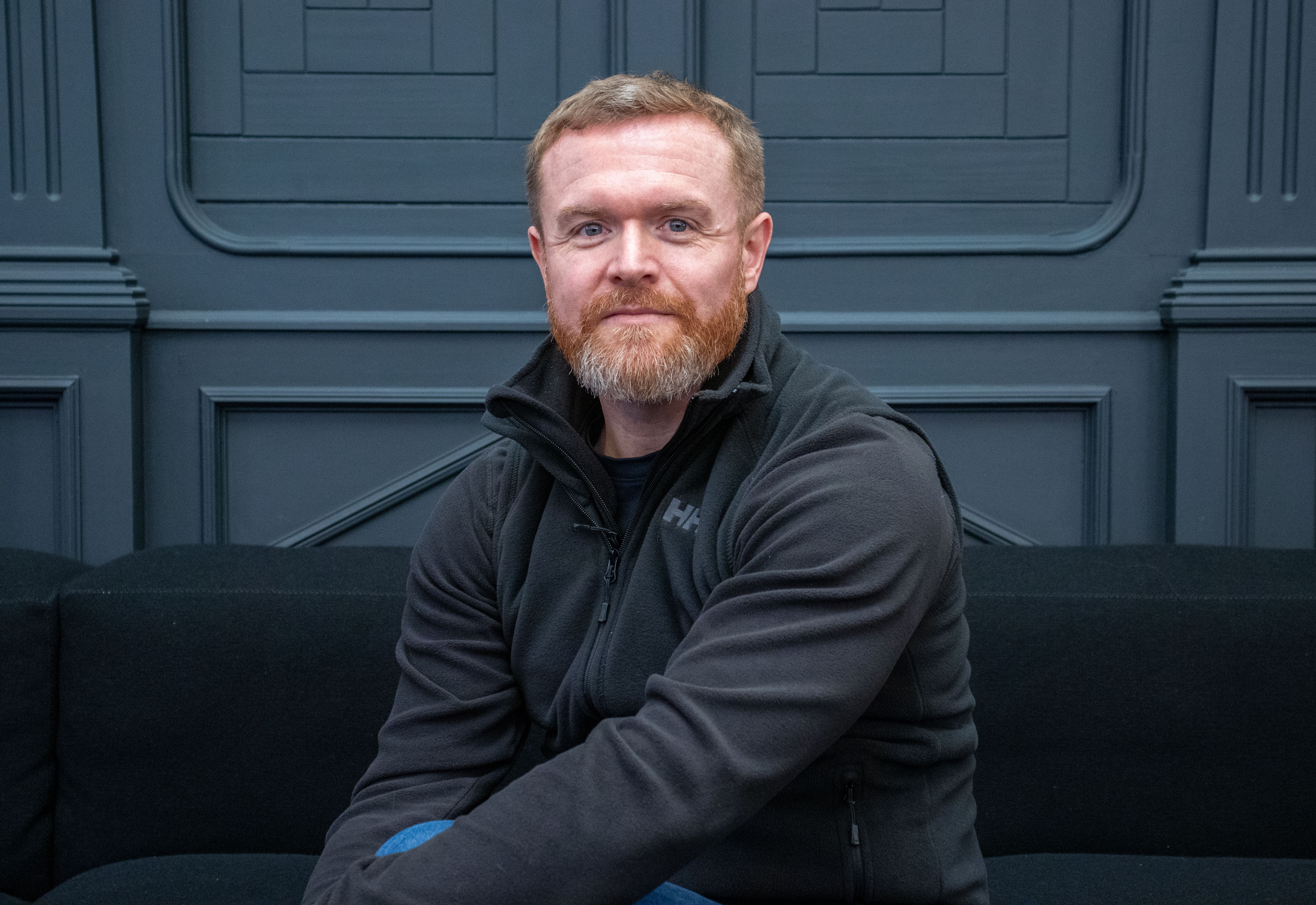 Will Semple sitting on a black sofa in Meter House