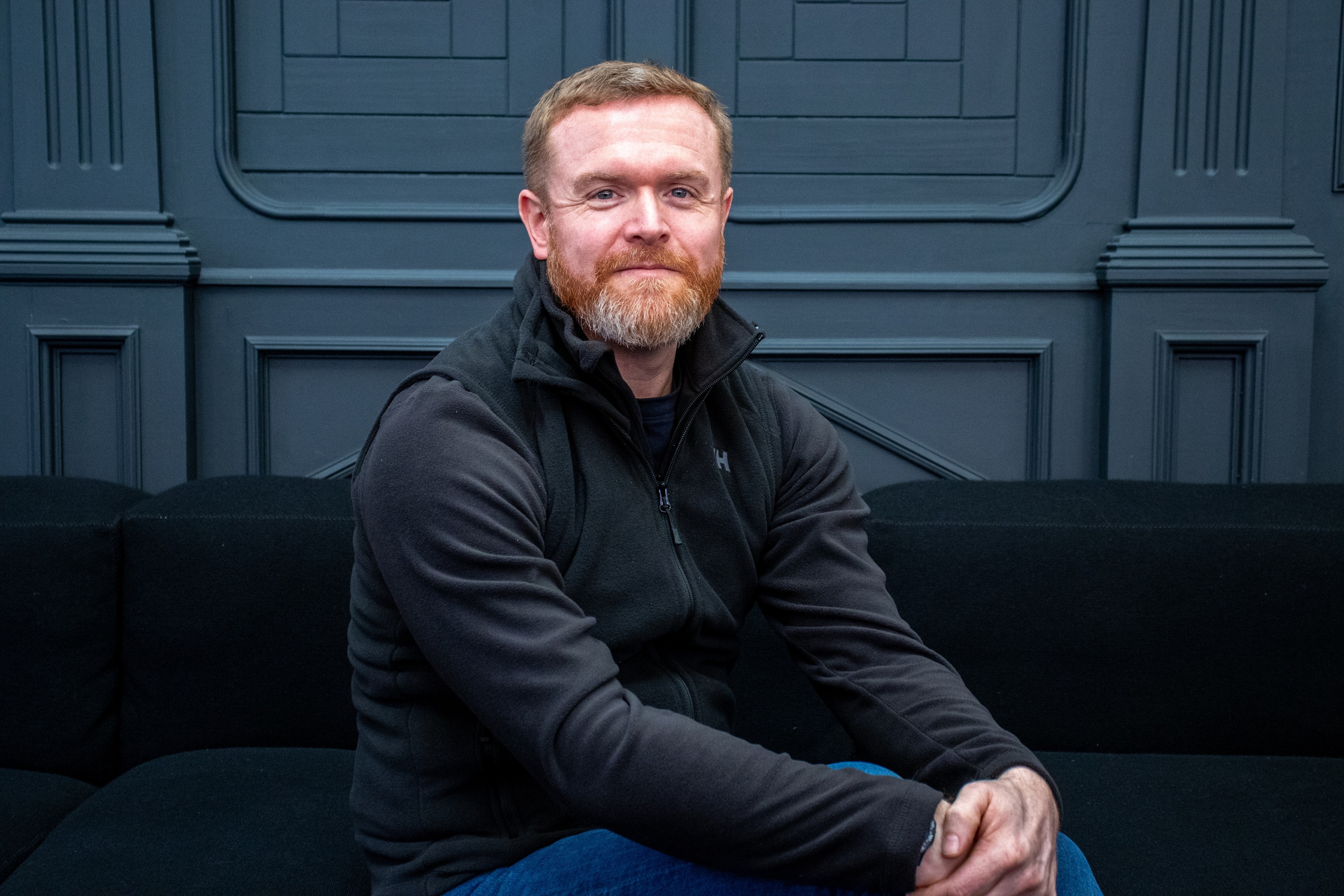 Will Semple sitting on a black sofa in Meter House