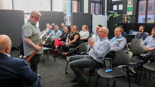 A man showing a sword to a room of people