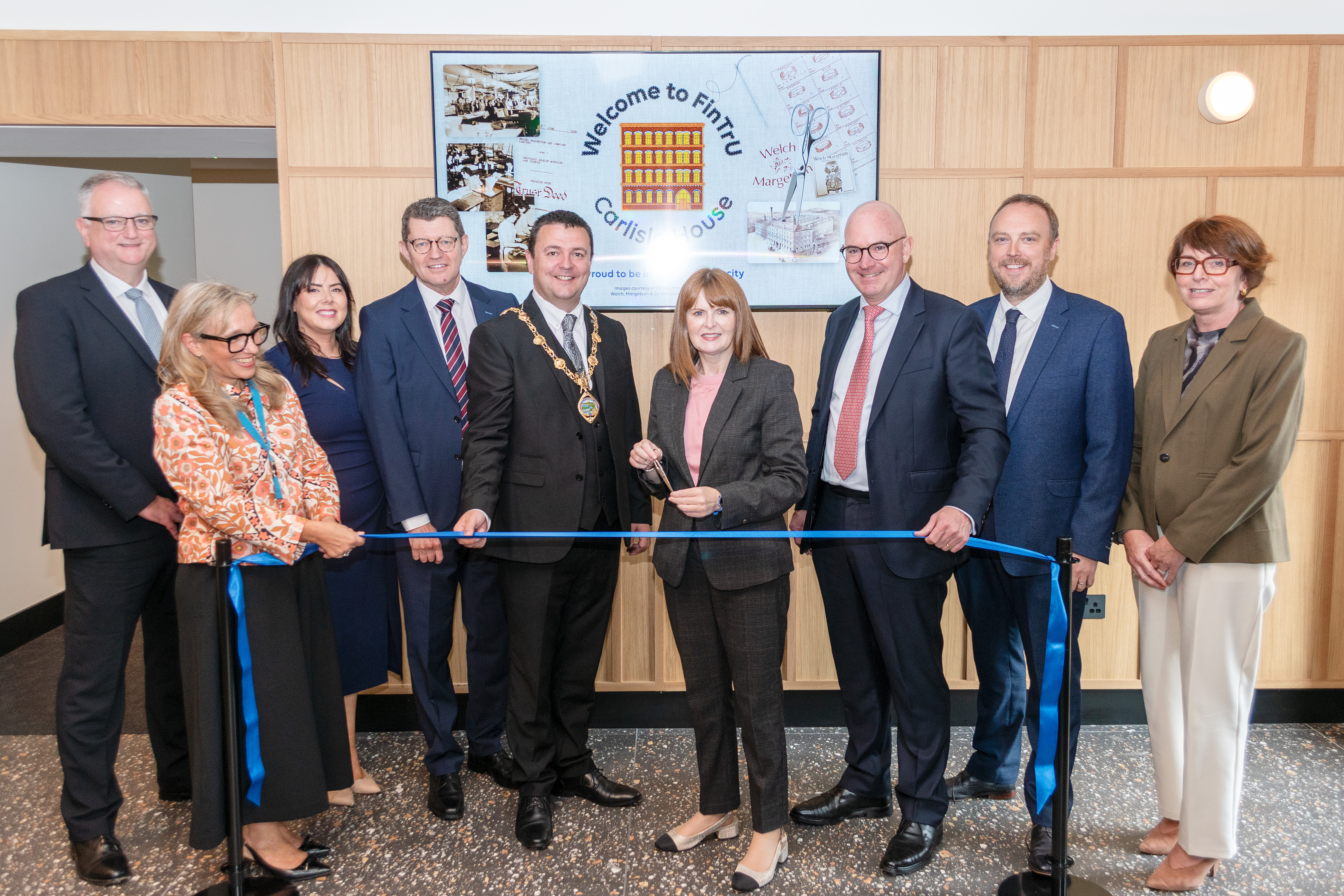 Economy Minister Caoimhe Archibald MLA cuts the ribbon at the official opening of Carlisle House alongside FinTrU's Executive Leadership team